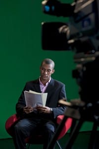 Man reading script in front of TV camera