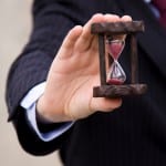 Businessman's hand holding hourglass