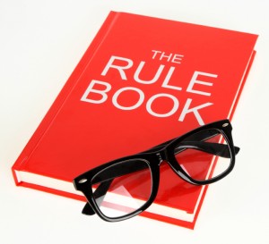 Pair of spectacles resting on a red rule book